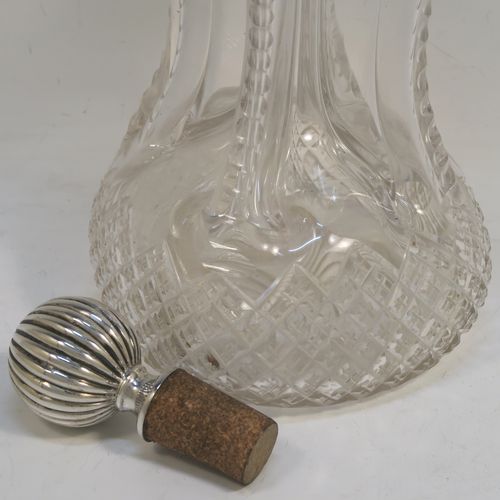 A large and very pretty Antique Victorian Sterling Silver and hand-cut crystal glug-glug decanter, having a hobnail pattern body, with four pinched and fluted central waists between, a plain round neck mount with four spouts, and a silver fluted and cork stopper. This beautiful antique silver and crystal decanter was made by Thomas Russell of Sheffield in 1894. The dimensions of this fine hand-made antique silver and crystal glug glug decanter are height 30 cms (11.75 inches), and width at base 12.5 cms (5 inches). Please note that this item is monogrammed opposite the hallmarks on the silver neck.