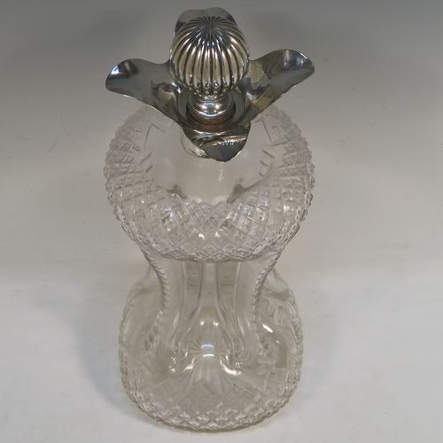 A large and very pretty Antique Victorian Sterling Silver and hand-cut crystal glug-glug decanter, having a hobnail pattern body, with four pinched and fluted central waists between, a plain round neck mount with four spouts, and a silver fluted and cork stopper. This beautiful antique silver and crystal decanter was made by Thomas Russell of Sheffield in 1894. The dimensions of this fine hand-made antique silver and crystal glug glug decanter are height 30 cms (11.75 inches), and width at base 12.5 cms (5 inches). Please note that this item is monogrammed opposite the hallmarks on the silver neck.