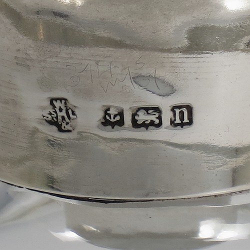 A pair of Antique Sterling Silver and cut-crystal decanters, having plain panelled bodies, plain round silver necks, with original hand-cut lobed stoppers, and all sitting on star-cut flat bases. Made by William Hutton and Sons Ltd., of Birmingham in 1912. The dimensions of this fine pair of antique silver and crystal decanters are height 27 cms (10.75 inches), and diameter at bases 10 cms (4 inches).