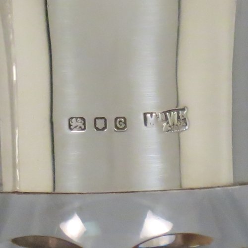 A Sterling Silver and hand-cut crystal pair of decanters, having tear-drop bodies and tapering sides, with hand-cut geometrical decoration, silver collars and lips, and original stoppers. Made by Mappin & Webb of London in 1938. The dimensions of these fine hand-made silver and crystal decanters are height 32 cms (12.5 inches), and diameter 12 cms (4.75 inches).   