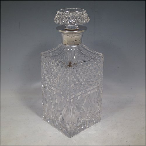 A Sterling Silver and hand-cut crystal decanter, having a square cross-section body with straight sides and hand-cut hobnail decoration, a plain silver collar, and original hand-cut stopper. Made in London in 1969, by I. Freeman & Sons Ltd. The dimensions of this fine hand-made silver and crystal decanter are height 23 cms (9 inches), and 9 cms (3.5 inches) square.  