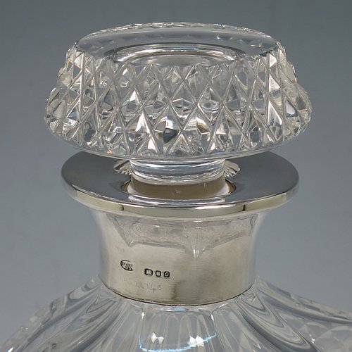 A Sterling Silver and hand-cut crystal decanter, having a square cross-section body with straight sides and hand-cut hobnail decoration, a plain silver collar, and original hand-cut stopper. Made in London in 1969, by I. Freeman & Sons Ltd. The dimensions of this fine hand-made silver and crystal decanter are height 23 cms (9 inches), and 9 cms (3.5 inches) square.
