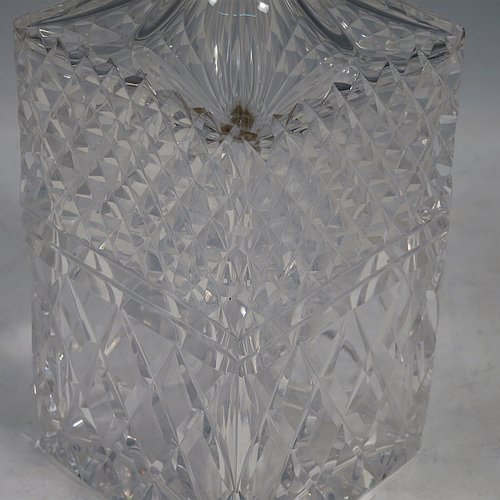 A Sterling Silver and hand-cut crystal decanter, having a square cross-section body with straight sides and hand-cut hobnail decoration, a plain silver collar, and original hand-cut stopper. Made in London in 1969, by I. Freeman & Sons Ltd. The dimensions of this fine hand-made silver and crystal decanter are height 23 cms (9 inches), and 9 cms (3.5 inches) square.