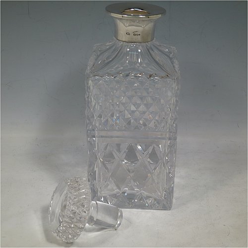 A Sterling Silver and hand-cut crystal decanter, having a square cross-section body with straight sides and hand-cut hobnail decoration, a plain silver collar, and original hand-cut stopper. Made in London in 1969, by I. Freeman & Sons Ltd. The dimensions of this fine hand-made silver and crystal decanter are height 23 cms (9 inches), and 9 cms (3.5 inches) square.