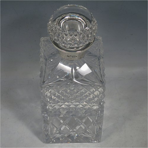 A Sterling Silver and hand-cut crystal decanter, having a square cross-section body with straight sides and hand-cut hobnail decoration, a plain silver collar, and original hand-cut stopper. Made in London in 1969, by I. Freeman & Sons Ltd. The dimensions of this fine hand-made silver and crystal decanter are height 23 cms (9 inches), and 9 cms (3.5 inches) square.