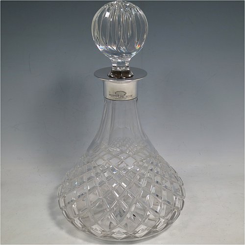 A Sterling Silver and hand-cut crystal decanter, having a round bellied body with tapering sides, hand-cut hobnail and diamond decoration, a silver collar with lip, an original fluted stopper, and sitting on a flat star-cut base. Made by Garrard & Co., of Birmingham in 1971. The dimensions of this fine silver and crystal decanter are height 28 cms (11 inches), and diameter at base 17 cms (6.75 inches).   