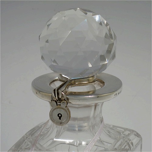 A very handsome pair of Sterling Silver and hand-cut crystal decanters with collar locking mechanisms, having square cross-section bodies with straight sides, hand-cut fluted and reeded decoration, silver collars with lockable clasps, padlocks, and keys, together with their original faceted stoppers. Made by William Gardener Groves of London in 1931. The dimensions of these fine hand-made silver and crystal lockable decanters are height 23 cms (9 inches), and width 8 cms (3.25 inches) square.