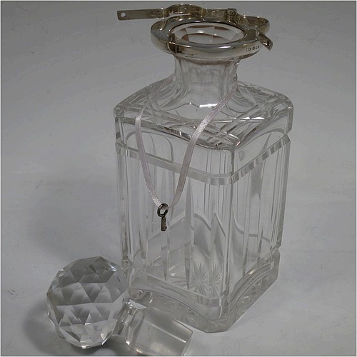 A very handsome pair of Sterling Silver and hand-cut crystal decanters with collar locking mechanisms, having square cross-section bodies with straight sides, hand-cut fluted and reeded decoration, silver collars with lockable clasps, padlocks, and keys, together with their original faceted stoppers. Made by William Gardener Groves of London in 1931. The dimensions of these fine hand-made silver and crystal lockable decanters are height 23 cms (9 inches), and width 8 cms (3.25 inches) square.