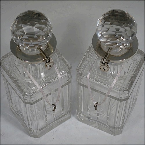 A very handsome pair of Sterling Silver and hand-cut crystal decanters with collar locking mechanisms, having square cross-section bodies with straight sides, hand-cut fluted and reeded decoration, silver collars with lockable clasps, padlocks, and keys, together with their original faceted stoppers. Made by William Gardener Groves of London in 1931. The dimensions of these fine hand-made silver and crystal lockable decanters are height 23 cms (9 inches), and width 8 cms (3.25 inches) square.