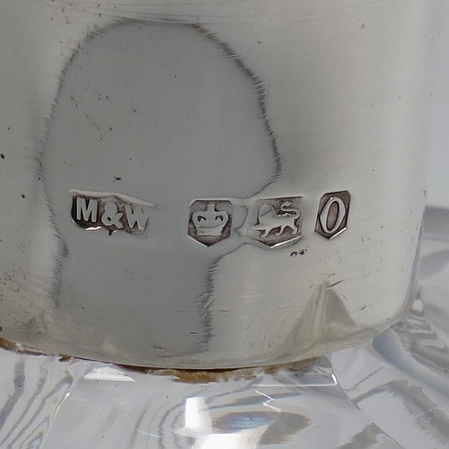 A very unusually designed Sterling Silver and hand-cut crystal decanter, having a main oval body at front and back with hobnail and star-burst cut, and with tapering sides having stepped decoration, a plain silver collar, an original hand-cut stopper, and sitting on a flat base with a matching star-cut. Made by Mappin and Webb of Sheffield in 1956. The dimensions of this fine hand-made silver and crystal decanter are height 25.5 cms (10 inches), width 12 cms (4.75 inches), and depth at base 7 cms (2.75 inches).