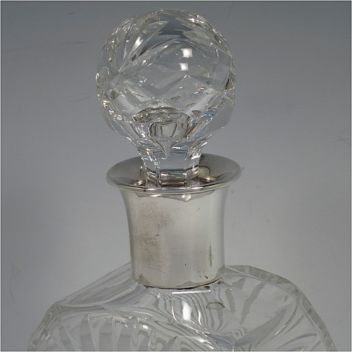 A very unusually designed Sterling Silver and hand-cut crystal decanter, having a main oval body at front and back with hobnail and star-burst cut, and with tapering sides having stepped decoration, a plain silver collar, an original hand-cut stopper, and sitting on a flat base with a matching star-cut. Made by Mappin and Webb of Sheffield in 1956. The dimensions of this fine hand-made silver and crystal decanter are height 25.5 cms (10 inches), width 12 cms (4.75 inches), and depth at base 7 cms (2.75 inches).