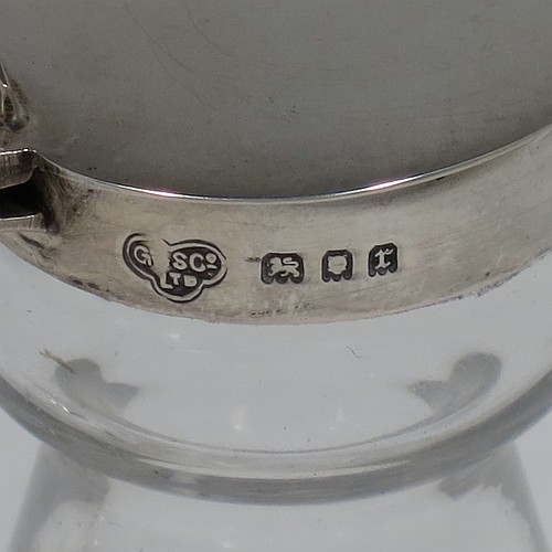 A Sterling Silver pair of whisky toddies or noggins, having round based hand-cut crystal bodies with tapering sides and loop handles, mounted with silver collars and hinged flat lids with thumb-pieces, all sitting on flat star-cut bases. Made by Goldsmiths and Silversmiths of London in 1932. The dimensions of this fine hand-made pair of silver and crystal noggins or toddies are height 11 cms (4.25 inches), and diameter at bases 6.5 cms (2.5 inches).   