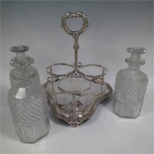A very handsome Antique Georgian Old Sheffield plated decanter stand, having three hand-cut crystal decanters with original stoppers, sitting inside a carrying frame with a cast anthemion leaf loop handle attached to a hand-chased reeded gallery, which in-turn is attached to a base with shell and gadroon border, and all sitting on three cast scroll feet. Made by Matthew Boulton of Birmingham in ca. 1810. The dimensions of this fine hand-made Old Sheffield plated decanter stand are height 28 cms (11 inches), and width at base 25.5 cms (10 inches).