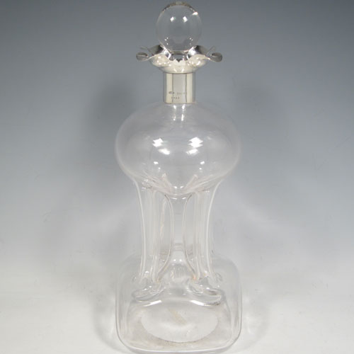 Antique Edwardian pair of sterling silver and cut-crystal glug-glug decanters, having plain bodies with pinched and fluted central waists, plain round necks with four pouring spouts, and original hand-cut stoppers. Made by John Grinsell of Birmingham in 1909. The dimensions of this fine pair of silver and crystal decanters are height 30 cms (11.75 inches), and width 11 cms (4.25 inches).