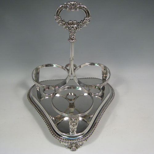 Antique Georgian sterling silver decanter stand with three decanters and frame with gadroon and rose borders. Made by William Bateman of London in 1824. Height 32 cms (12.5 inches), width 23 cms (9 inches). Weight 31.5 troy ounces (977g).