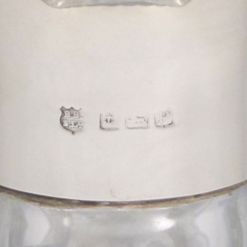 Sterling silver and hand-cut crystal decanter, having a square cross-section body with tapering sides, hand-cut fluted decoration, a silver collar with lip, and original fluted stopper. Made by Barker Brothers Ltd., of Birmingham in 1939. The dimensions of this fine silver and crystal decanter are height 23 cms (9 inches), and width 10 cms (4 inches).