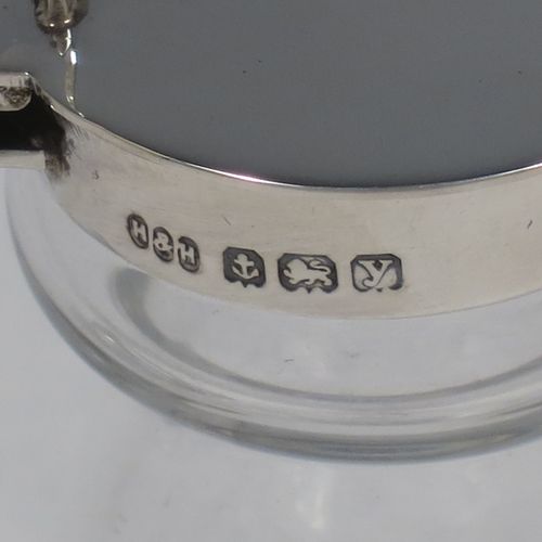 A very handsome pair of Sterling Silver and crystal whisky toddies or noggins, having round based hand-cut crystal bodies with tapering sides and loop handles, mounted with silver collars and hinged flat lids with thumb-pieces, all sitting on flat star-cut bases. Made by Hukin and Heath of Birmingham in 1923. The dimensions of this fine hand-made pair of silver and crystal noggins or toddies are height 11 cms (4.25 inches), and diameter at bases 6.5 cms (2.5 inches).