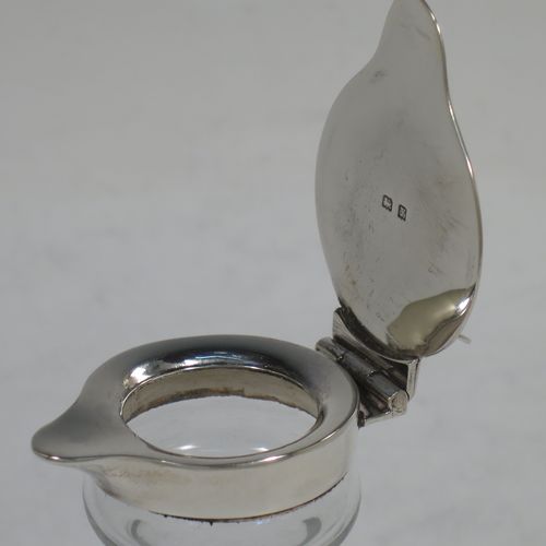 A very handsome pair of Sterling Silver and crystal whisky toddies or noggins, having round based hand-cut crystal bodies with tapering sides and loop handles, mounted with silver collars and hinged flat lids with thumb-pieces, all sitting on flat star-cut bases. Made by Hukin and Heath of Birmingham in 1923. The dimensions of this fine hand-made pair of silver and crystal noggins or toddies are height 11 cms (4.25 inches), and diameter at bases 6.5 cms (2.5 inches).