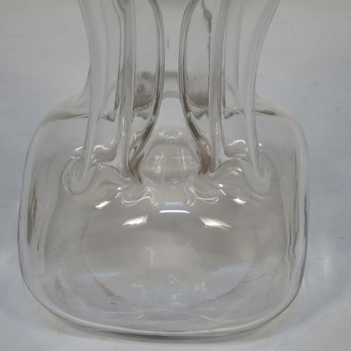 A handsome Antique Victorian Sterling Silver and cut-crystal glug-glug decanter, having a plain and clear body with pinched and fluted central waists, a plain round neck with four pouring spouts, and original hand-cut stopper. Made by William Hutton and Sons of Birmingham in 1901. The dimensions of this fine hand-made antique silver and crystal glug glug decanter are height 27.5 cms (10.75 inches), and width at base 13 cms (5 inches).