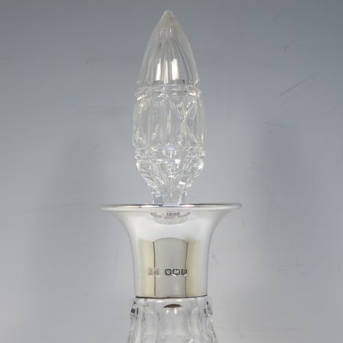 A very handsome Antique Sterling Silver and hand-cut crystal decanter, having a tear-drop shaped body with tapering sides, with hand-cut geometrical decoration, a silver collar and lip, and with original stopper. This elegant silver and crystal decanter was made by R. F. Mosley and Co., of of Sheffield in 1922. The dimensions of this fine hand-made antique silver and crystal decanter are height 32.5 cms (12.75 inches), and diameter at base 11.5 cms (4.5 inches).
