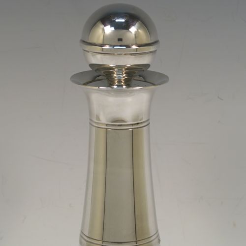 A very elegant Silver Plated and hand-blown glass bodied decanter, having a plain round silver-plated long neck with two bands of hand-chased reeded decoration, an original plain round silver-plated stopper, and a plain round glass body. This handsome silver-plated decanter was made in ca. 1960. The dimensions of this fine hand-made silver plated and glass decanter are height 26 cms (10.25 inches), and 13.5 cms (5.25 inches) in diameter at its widest point.