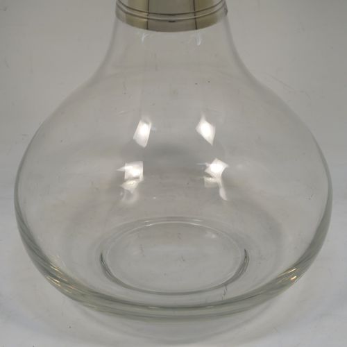 A very elegant Silver Plated and hand-blown glass bodied decanter, having a plain round silver-plated long neck with two bands of hand-chased reeded decoration, an original plain round silver-plated stopper, and a plain round glass body. This handsome silver-plated decanter was made in ca. 1960. The dimensions of this fine hand-made silver plated and glass decanter are height 26 cms (10.25 inches), and 13.5 cms (5.25 inches) in diameter at its widest point.