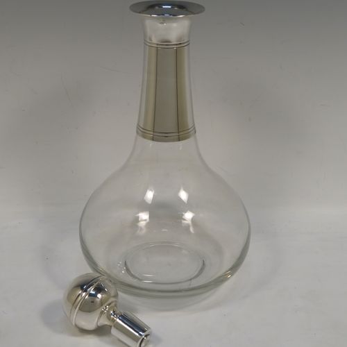 A very elegant Silver Plated and hand-blown glass bodied decanter, having a plain round silver-plated long neck with two bands of hand-chased reeded decoration, an original plain round silver-plated stopper, and a plain round glass body. This handsome silver-plated decanter was made in ca. 1960. The dimensions of this fine hand-made silver plated and glass decanter are height 26 cms (10.25 inches), and 13.5 cms (5.25 inches) in diameter at its widest point.