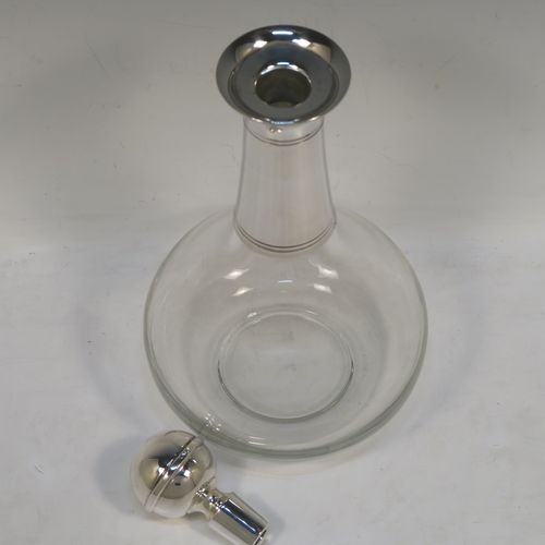A very elegant Silver Plated and hand-blown glass bodied decanter, having a plain round silver-plated long neck with two bands of hand-chased reeded decoration, an original plain round silver-plated stopper, and a plain round glass body. This handsome silver-plated decanter was made in ca. 1960. The dimensions of this fine hand-made silver plated and glass decanter are height 26 cms (10.25 inches), and 13.5 cms (5.25 inches) in diameter at its widest point.
