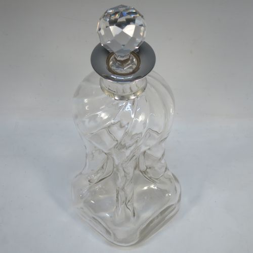 A very pretty Antique Edwardian Sterling Silver and cut-crystal glug-glug decanter, having swirl-flute shoulders and clear bottom body, with four pinched and fluted central waists between, a plain round neck mount, and a hand-cut spherical and faceted crystal stopper. Made in Birmingham in 1909. The dimensions of this fine hand-made antique silver and crystal glug glug decanter are height 28.5 cms (11.25 inches), and width at base 11.5 cms (4.5 inches).