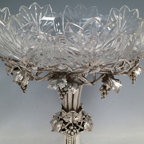 A very pretty Antique Victorian Sterling Silver compote or dessert stand with applied cast grape vine work, and sitting on a pedestal foot with hand-chased anthemion leaves, together with a hand-cut crystal bowl. Made by the Barnard Brothers of London in 1856. The dimensions of this fine hand-made antique silver and crystal dessert or compote stand are height 28 cms (11 inches), diameter of bowl 25.5 cms (10 inches), and it weighs approx. 1,273g (41 troy ounces).
