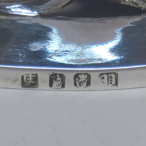 A very beautiful Irish Antique Edwardian Sterling Silver large table dish ring, having a hand-pierced and chased body decorated with scrolls, two cottages, a castle, and a bridge, a vacant oval cartouche, and a blue-glass liner. Made by Edmund Johnson of Dublin in 1910. The dimensions of this fine hand-made antique silver dish ring are height 9 cms (3.5 inches), diameter at base 19 cms (7.5 inches), and it weighs approx. 302g (9.7 troy ounces).