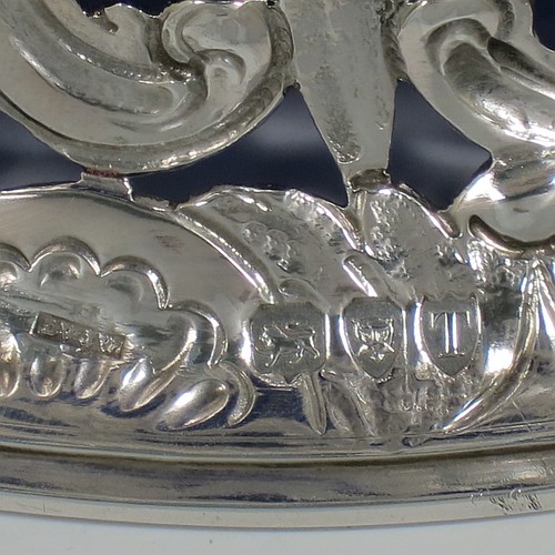 An Antique Victorian Sterling Silver large table dish ring in an Irish style, having a hand-pierced and chased body decorated with pastoral scenes, figures, animals, a vacant oval cartouche, and a blue-glass liner. Made by D. and J. Welby of London in 1894. The dimensions of this fine hand-made antique silver dish ring are height 7.5 cms (3 inches), diameter at base 19 cms (7.5 inches), and it weighs approx. 351g (11.3 troy ounces).