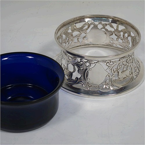 A handsome Antique Victorian Sterling silver miniature dish ring, in an Irish style, having a hand-pierced and chased body with with pastoral scenes, figures, animals, a vacant oval cartouche, and a blue-glass liner. Made by John and Frank Pairpoint of London in 1901. The dimensions of this fine hand-made antique miniature silver dish ring are height 5 cms (2 inches), diameter at base 11 cms (4.3 inches), and it weighs approx. 108g (3.5 troy ounces).