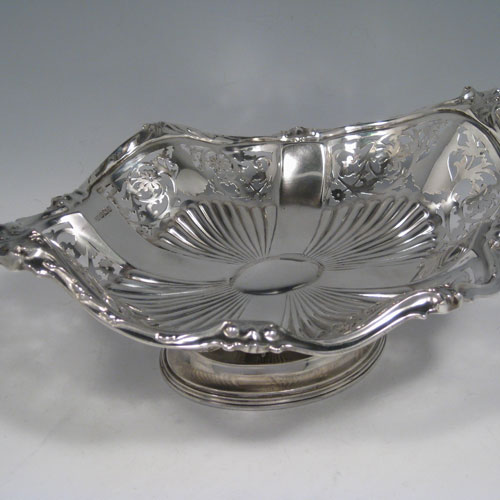 Antique Edwardian sterling silver dish, having a hand-pierced oval shaped body, with cast floral border, and sitting on a pedestal foot. Made by George Howson of Sheffield in 1909. The dimensions of this fine hand-made silver dish are length 29 cms (11.5 cms), width 22.5 cms (8.75 inches), height 10 cms (4 inches) and it weighs approx. 578g (18.6 troy ounces).