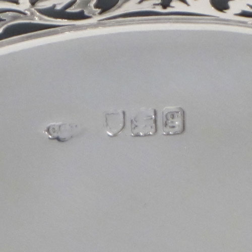 Antique Edwardian sterling silver bread roll table dish, having an oval body with hand-pierced geometrical and floral decoration, with an applied shaped reeded border, with two scroll side handles, and sitting on a flat base. Made by Charles Clement Pilling of London in 1902. The dimensions of this fine hand-made silver bread dish are length 32.5 cms (12.75 inches), width 18 cms (7 inches), height 6.5 cms (2.5 inches), and it weighs approx. 304g (9.8 troy ounces).