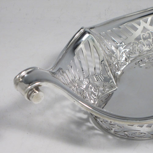 Antique Edwardian sterling silver bread roll table dish, having an oval body with hand-pierced geometrical and floral decoration, with an applied shaped reeded border, with two scroll side handles, and sitting on a flat base. Made by Charles Clement Pilling of London in 1902. The dimensions of this fine hand-made silver bread dish are length 32.5 cms (12.75 inches), width 18 cms (7 inches), height 6.5 cms (2.5 inches), and it weighs approx. 304g (9.8 troy ounces).
