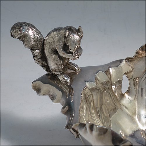 An Antique Victorian Silver Plated very unusual squirrel nut dish, having an oval body all hand-chased and made to look like half a walnut, with a cast squirrel handle, and sitting on four cast foliate feet. Made by the Pairpoint Brothers of Sheffield in ca. 1880. The dimensions of this fine hand-made antique silver-plated bread dish are length 28 cms (11 inches), width 19 cms (7.5 inches), and height 13 cms (5 inches).
