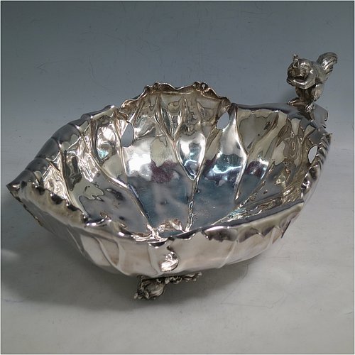 An Antique Victorian Silver Plated very unusual squirrel nut dish, having an oval body all hand-chased and made to look like half a walnut, with a cast squirrel handle, and sitting on four cast foliate feet. Made by the Pairpoint Brothers of Sheffield in ca. 1880. The dimensions of this fine hand-made antique silver-plated bread dish are length 28 cms (11 inches), width 19 cms (7.5 inches), and height 13 cms (5 inches).