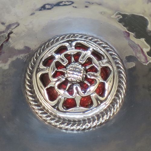 A very beautiful Sterling Silver Arts and Crafts table dish, having a round hand-hammered body, with an applied reed cog border, a central Tudor Rose style boss with an applied rope-twist border and dark red enamel underneath showing through the piercing, and all sitting on a collet foot. Made by Omar Ramsden of London in 1923. The dimensions of this fine hand-made Arts and Crafts silver dish are diameter 11 cms (4.3 inches), and it weighs approx. 93g (3 troy ounces).