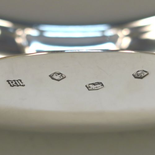 A very large, heavy, and handsome Sterling Silver strawberry dish, having a plain round body, with a raised flat ground, melon fluted sides with hand-chased lobed edges. This elegant silver dish was made by the Royal Irish Silver Co., of London in 1973. The dimensions of this fine hand-made table dish are diameter 33 cms (13 inches), height 8.5 cms (3.3 inches), and it weighs approx. 1,302g (42 troy ounces).