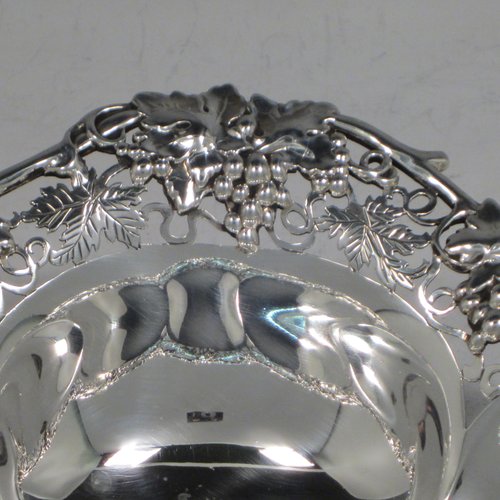 Sterling silver dish, having a shaped and lobed round body, with an applied and hand-pierced border showing grape-vine and leaf decoration, and sitting on a flat base. Made by Henry Atkins of Sheffield in 1943. The dimensions of this fine hand-made silver dish are diameter 23 cms (9 inches), height 5 cms (2 inches), and it weighs approx. 387g (12.8 troy ounces).