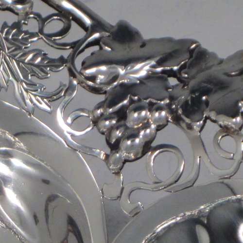 Sterling silver dish, having a shaped and lobed round body, with an applied and hand-pierced border showing grape-vine and leaf decoration, and sitting on a flat base. Made by Henry Atkins of Sheffield in 1943. The dimensions of this fine hand-made silver dish are diameter 23 cms (9 inches), height 5 cms (2 inches), and it weighs approx. 387g (12.8 troy ounces).