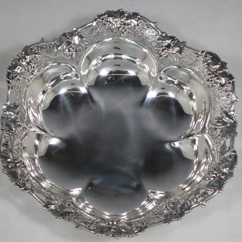 Sterling silver dish, having a shaped and lobed round body, with an applied and hand-pierced border showing grape-vine and leaf decoration, and sitting on a flat base. Made by Henry Atkins of Sheffield in 1943. The dimensions of this fine hand-made silver dish are diameter 23 cms (9 inches), height 5 cms (2 inches), and it weighs approx. 387g (12.8 troy ounces).