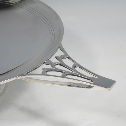 A Sterling Silver Art Deco very stylish serving dish, having a plain round body, with a band of hand-engraved reed-work, and two hand-pierced handles, all sitting on a pedestal foot. Made by William Naylor of Birmingham in 1935. The dimensions of this fine hand-made silver Art Deco dish are width across handles 36.5 cms (14.3 inches), height 7.5 cms (3 inches), and it weighs approx. 520g (16.8 troy ounces).