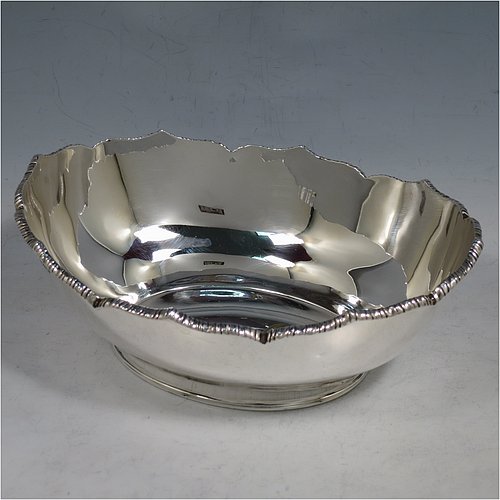 An Antique Edwardian Sterling Silver bread roll table dish, having an oval plain body with an applied wavey-edged rope-twist or gadroon border, and sitting on a flat base. Made by William Hutton & Sons of Sheffield in 1908. The dimensions of this fine hand-made antique silver bread dish are length 20 cms (8 inches), width 15 cms (6 inches), height 7 cms (2.75 inches), and it weighs approx. 285g (9.2 troy ounces).   