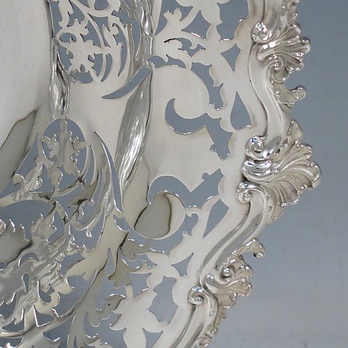 An Antique Edwardian Sterling Silver serving dish, having a round body, with an applied cast scroll and shell border, a hand-pierced body with floral decoration, and sitting on a plain flat collet foot. Made by Alexander Clark of Sheffield in 1906. The dimensions of this fine hand-made antique silver serving dish are 27 cms (10.5 inches) diameter, height 6 cms (2.3 inches), and it weighs approx. 460g (14.8 troy ounces).