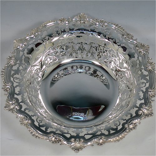 An Antique Edwardian Sterling Silver serving dish, having a round body, with an applied cast scroll and shell border, a hand-pierced body with floral decoration, and sitting on a plain flat collet foot. Made by Alexander Clark of Sheffield in 1906. The dimensions of this fine hand-made antique silver serving dish are 27 cms (10.5 inches) diameter, height 6 cms (2.3 inches), and it weighs approx. 460g (14.8 troy ounces).