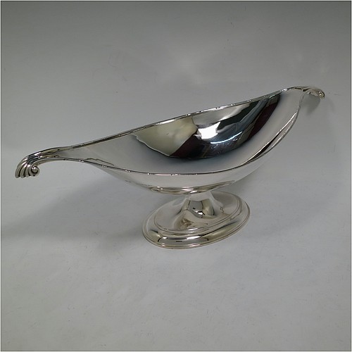 An Antique Edwardian Sterling Silver Arts and Crafts style plain oval table dish or bowl, having an applied ribbon & reed border, with fluted and scroll handles, and sitting on a stepped pedestal base. Made by Elkington & Co., of Birmingham in 1907. The dimensions of this fine hand-made antique silver Arts & Crafts bowl or dish are length 38 cms (15 inches), width 13.5 cms (5.3 inches), height 13 cms (5 inches), and it weighs of approx. 573g (18.5 troy ounces).