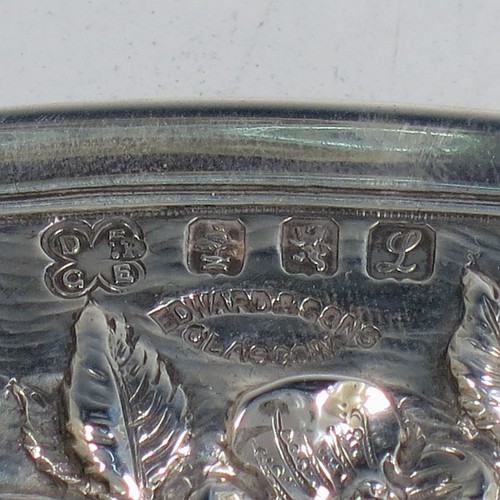 A very pretty Scottish Sterling Silver Arts and Crafts style table dish, having a round hand-hammered body, with an applied scroll border and hand-chased floral wild rose and thorn-leaf decoration. Made by Edward and Sons of Glasgow in 1922. The dimensions of this fine hand-made Arts and Crafts silver dish are diameter 18 cms (7 inches), and it weighs approx. 203g (6.5 troy ounces).