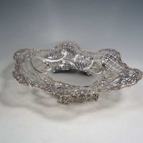 Antique Victorian sterling silver dish, having hand-pierced decoration with swags and bows, with a cast foliate border, and sitting on a matching cast foliate foot. Made by William Comyns of London in 1894. The dimensions of this fine hand-made silver table dish are length 36 cms (14.25 inches), width 28 cms (11 inches), height 10 cms (4 inches), and it weighs approx. 25 troy ounces (775g).